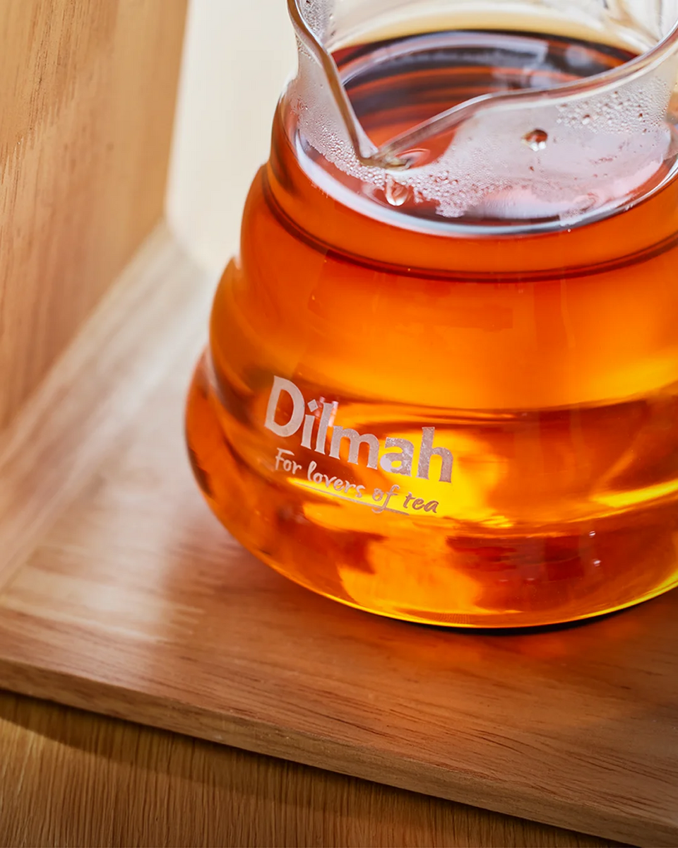 Dilmah tea pot with tea on a wooden surface